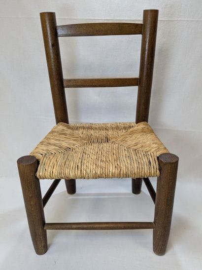 Wooden children's chair with a straw seat....