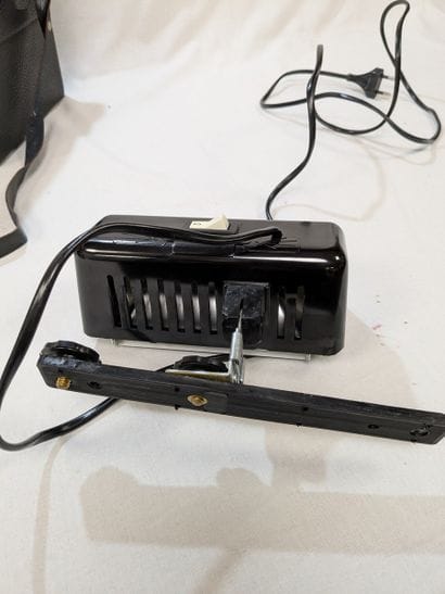 Black lacquered metal camera flash, in a...