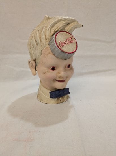 COCA-COLA. A painted cast-iron piggy bank...