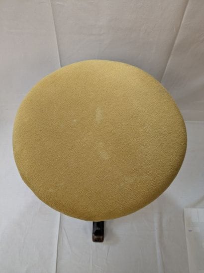 Tabouret tripode en bois noirci. Assise garnie...