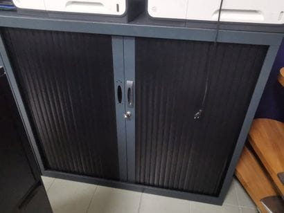 Une armoire métallique noire à rideau ainsi...