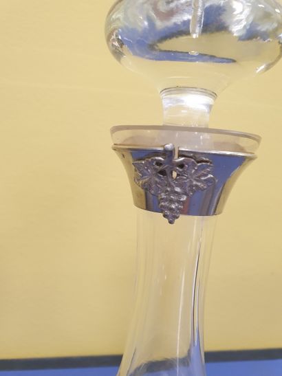 A decanter adorned with a bunch of grapes...