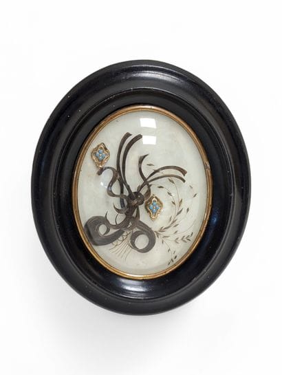 Oval frame decorated with hair souvenirs,...
