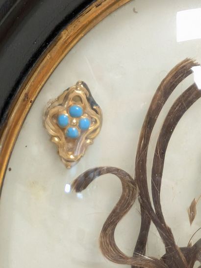 Oval frame decorated with hair souvenirs,...
