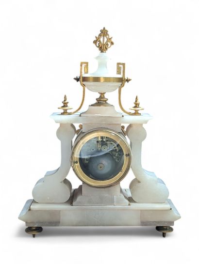 Pendule portique en albâtre sculpté. Elle...