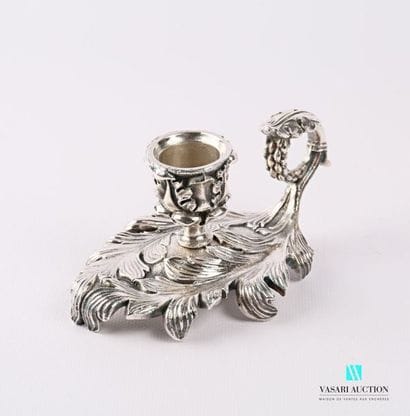 A silver bronze hand candleholder resting...