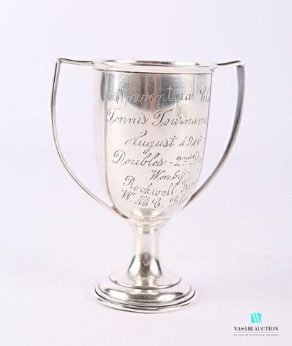 A silver cup in the form of a baluster resting...