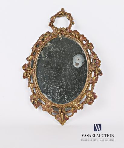 A bronze mirror with an oval view, it is...
