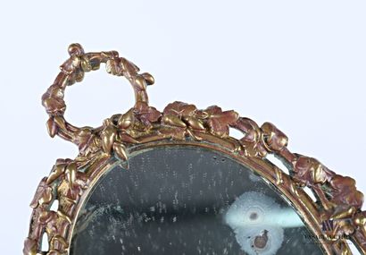 A bronze mirror with an oval view, it is...