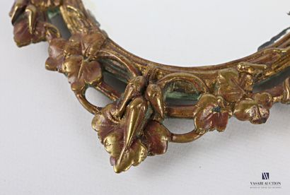 A bronze mirror with an oval view, it is...