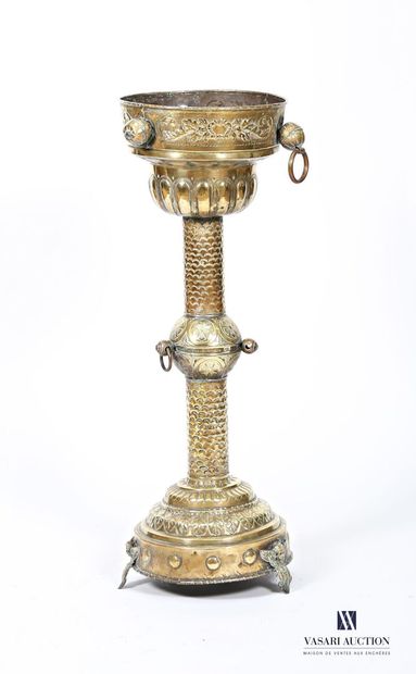 Embossed brass stand on a round base terminating...