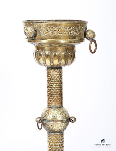 Embossed brass stand on a round base terminating...