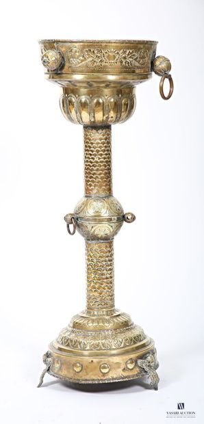 Embossed brass stand on a round base terminating...