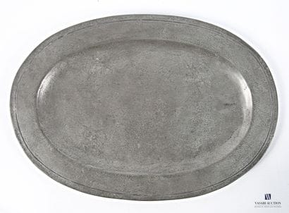 A pewter oval soup tureen and its base, flanked...