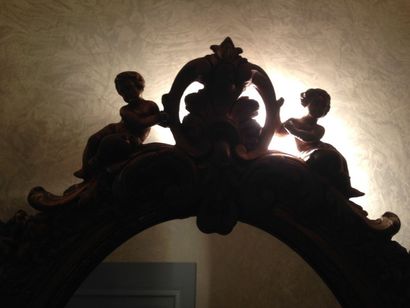 Petit miroir ovale en bois doré orné de putti...