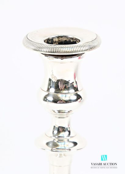 A pair of silver-plated candlesticks on a...