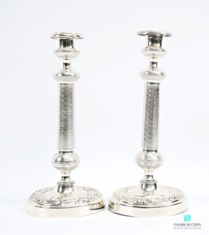 A pair of silver-plated candlesticks on a...