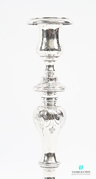 A pair of silver-plated candlesticks on a...