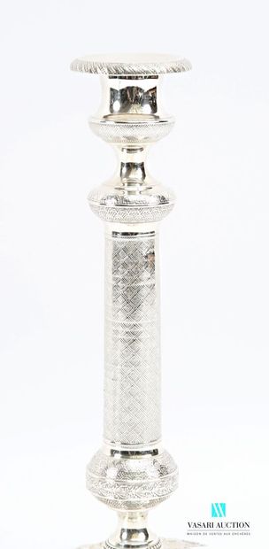A pair of silver-plated candlesticks on a...