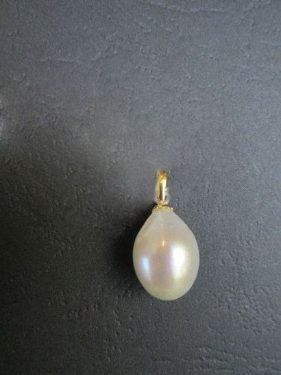 Pendentif en or jaune agrémenté d’une perle

de...