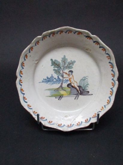 Assiette en faïence à décor d'un enfant et...