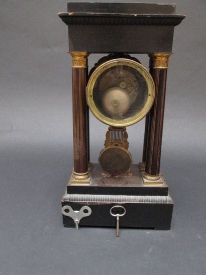 Pendule en bois marqueté, le cadrant inscrit...