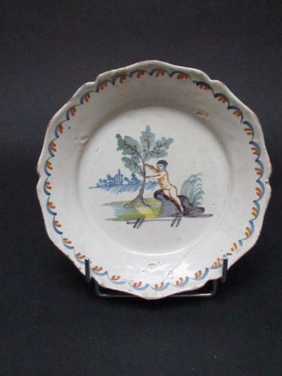 Assiette en faïence à décor d'un enfant et...