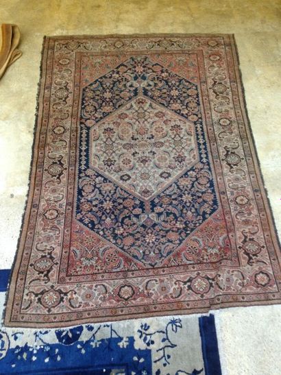 Tapis à décor d'un médaillon sur fond rose...