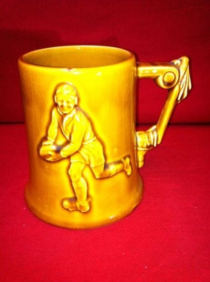 Chope à bière en faience jaune avec joueur...