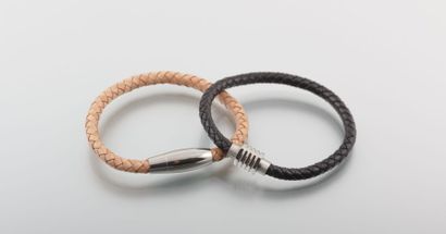Deux bracelets en cuirs tressés, l'un beige...