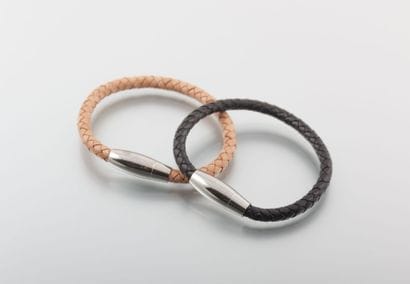 Deux bracelets en cuirs tressés, l'un beige...