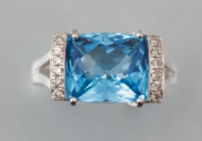 Bague en or blanc ornée d'une topaze

bleue...
