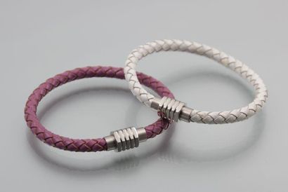 Deux bracelets de cuir tressé, l'un bordeaux...