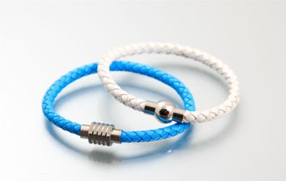Deux bracelets en cuir tressé, l'un blanc...