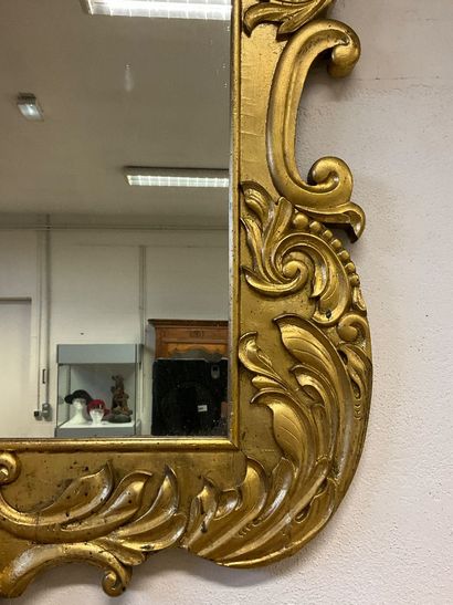 Glass with gilded frame and plant motif....