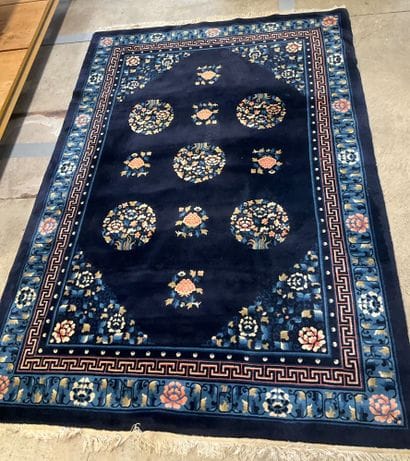 Midnight-blue wool rug with pink floral design.
Dimensions:...