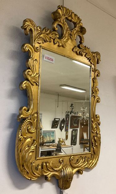 Glass with gilded frame and plant motif....