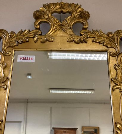 Glass with gilded frame and plant motif....