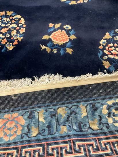 Midnight-blue wool rug with pink floral design.
Dimensions:...
