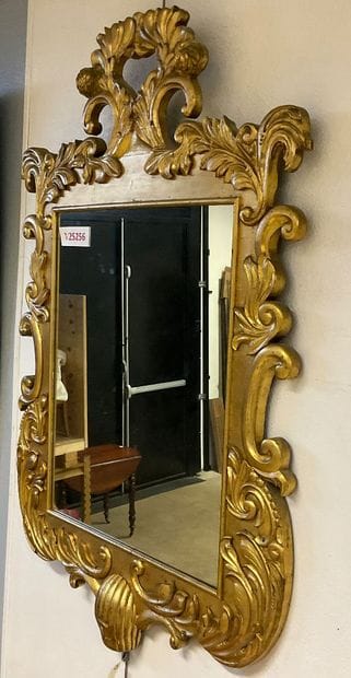 Glass with gilded frame and plant motif....