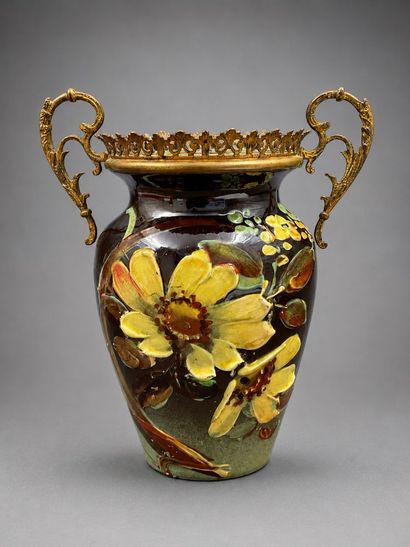 Vase en faïence à décor de fleurs surmonté...