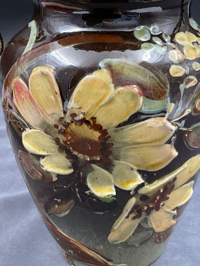 Vase en faïence à décor de fleurs surmonté...