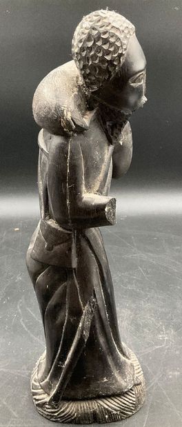 A statuette depicting a saint carrying a...