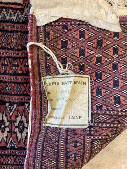 2 rugs: a handwoven wool Bukhara-style hallway...