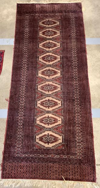 2 rugs: a handwoven wool Bukhara-style hallway...