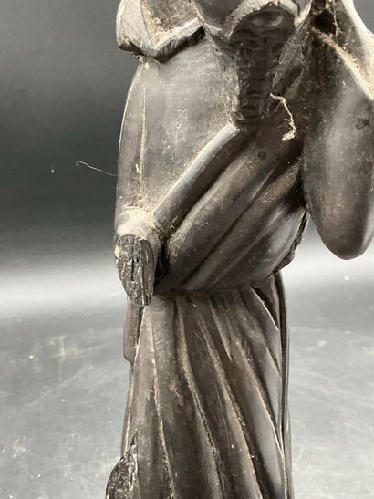 A statuette depicting a saint carrying a...