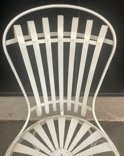 A riveted iron garden chair with a slatted...