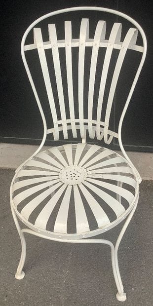 A riveted iron garden chair with a slatted...