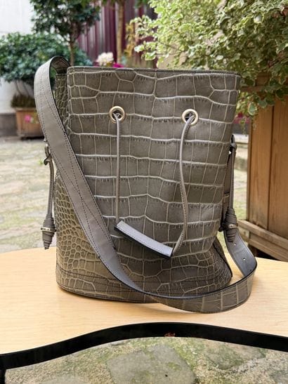 LANCEL 
Grand sac seau en cuir gris effet...