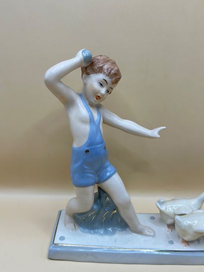 ROYAL DUX 
Enfant poursuivant deux oies en...